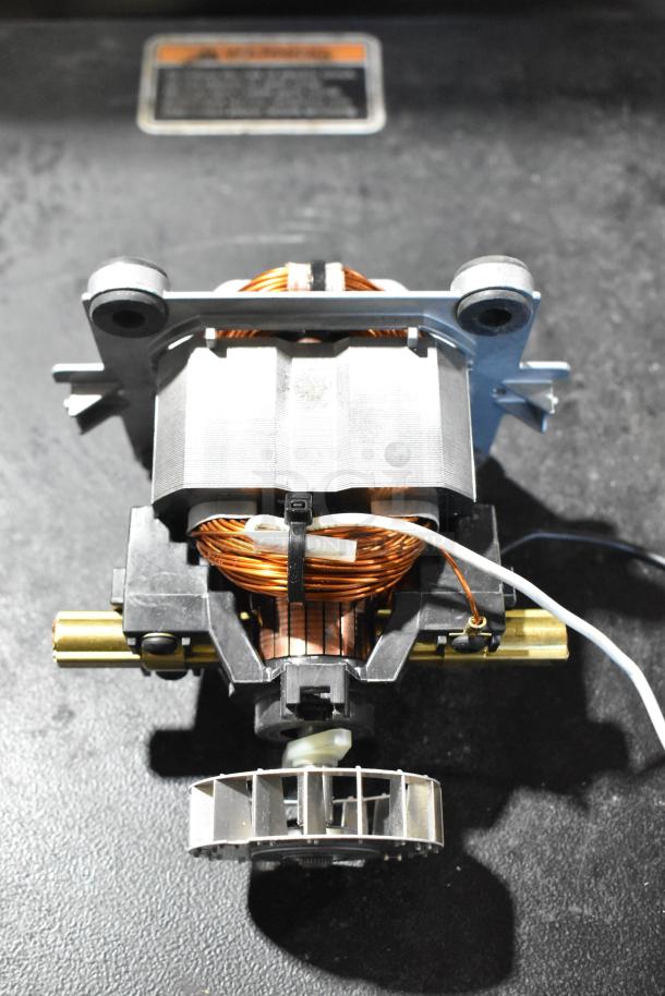 Bison 122485-00 motor part, brand new, with coil and metal components, some cosmetic scratches visible.