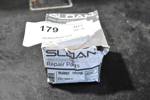 Damaged box of Sloan repair parts, model EBV129A-C, showing scratches and dents. Product code: 3325450.