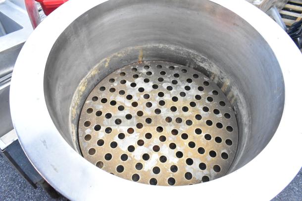 Stainless steel kettle with a perforated interior, showing signs of wear. Ideal for industrial use.