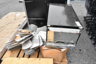 Assorted auction items including an Igloo IRF32BK mini cooler, metal fan blades, and plastic strip curtain rolls on a pallet.