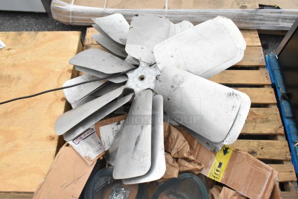 12 various items on a pallet, including metal fan blades. Igloo IRF32BK mini cooler and plastic strip curtain rolls not shown.