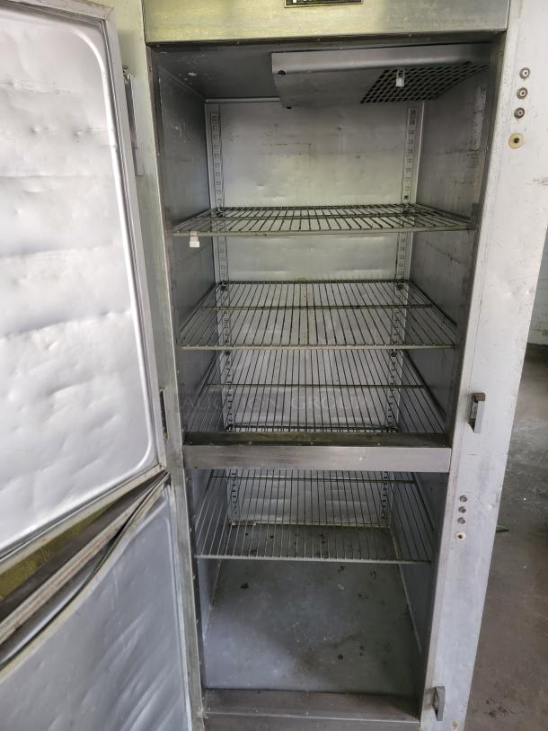 Traulsen G12000 commercial reach-in freezer with three shelves, open door view. Good condition, ideal for professional kitchens.