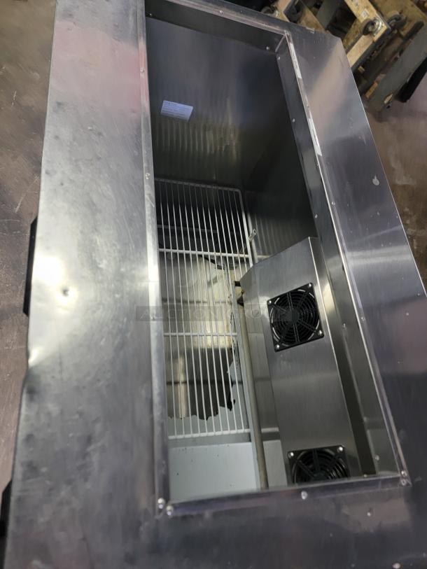 Cooltech CUST60BA commercial refrigerated prep table with stainless steel top, internal view showing cooling fans and shelving.