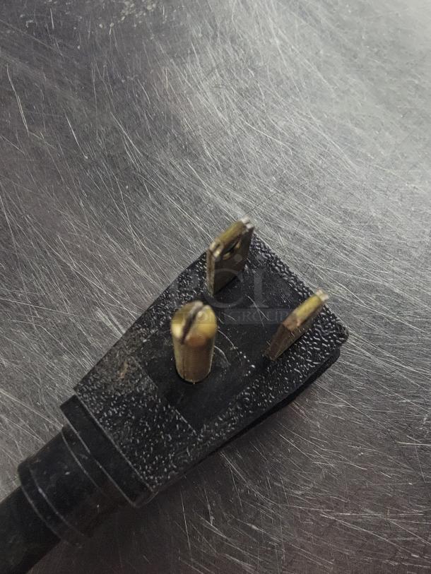 Close-up of a black three-prong plug on a Leader Refrigeration undercounter fridge/freezer model LB48S/C.