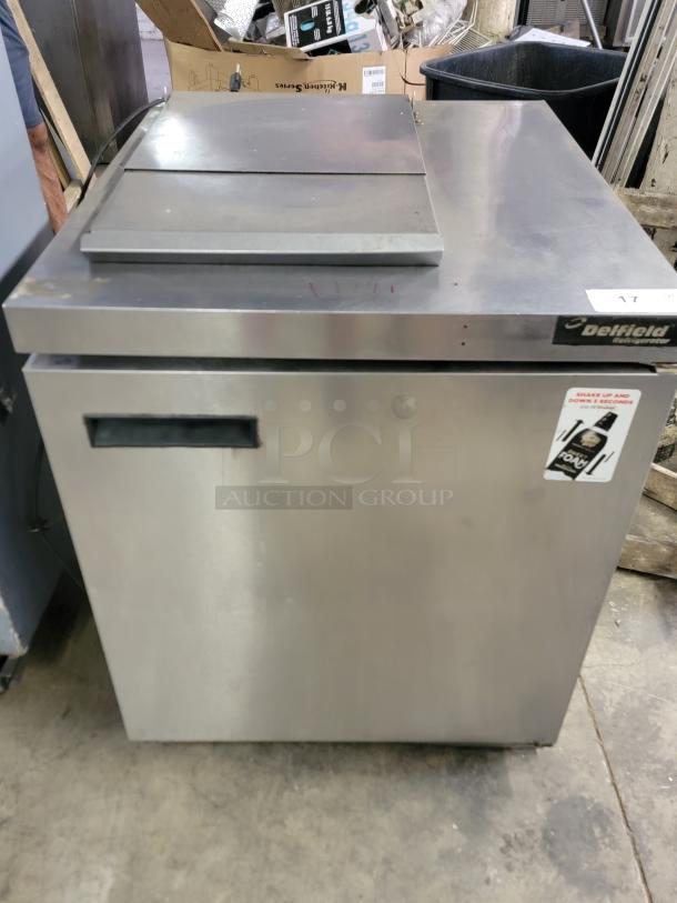 Delfield UC4427N-6M-DD1 refrigerated prep table in stainless steel, with top prep surface and refrigerated door compartment, good condition.