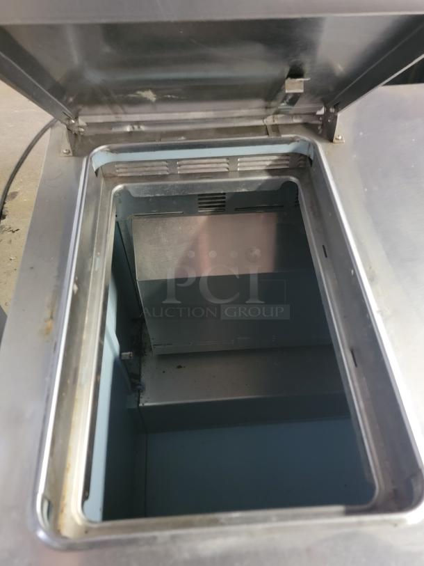 Delfield refrigerated prep table, model UC4427N-6M-DD1. Open top showing interior. Good condition. Ideal for kitchens.