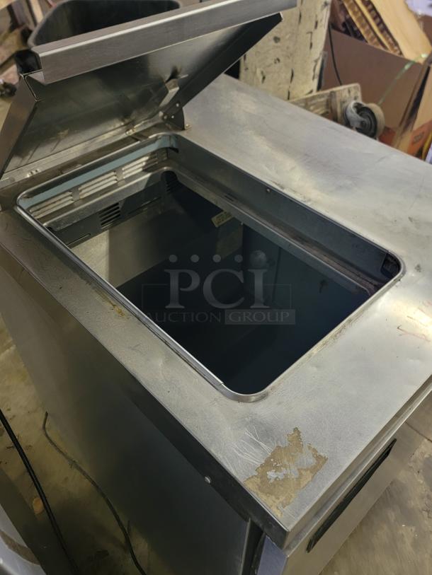 Delfield UC4427N-6M-DD1 refrigerated prep table, open lid, showing interior, minor surface wear visible.