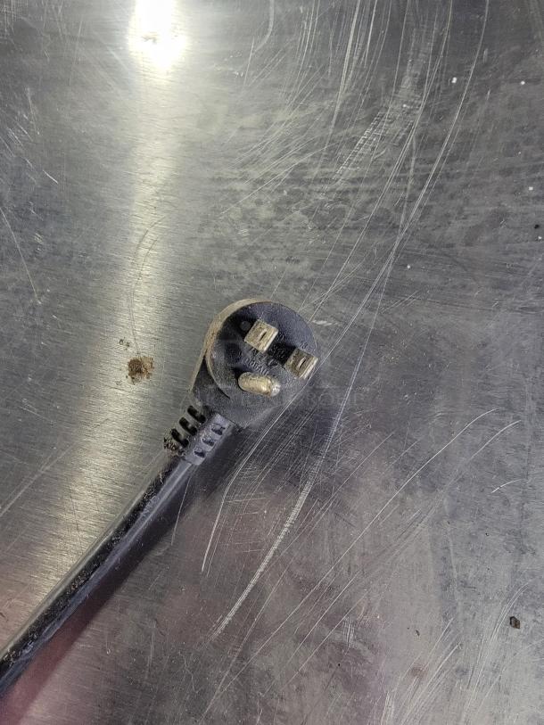 Close-up of a three-prong plug on a Manitowoc Delfield 436-STAR2 undercounter refrigerator. Plug appears slightly worn.
