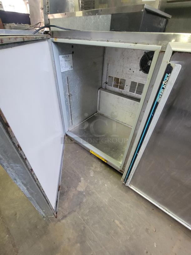 Stainless steel Silver King SKR48 refrigerator, open door view, showing interior space and cooling vents; used condition.