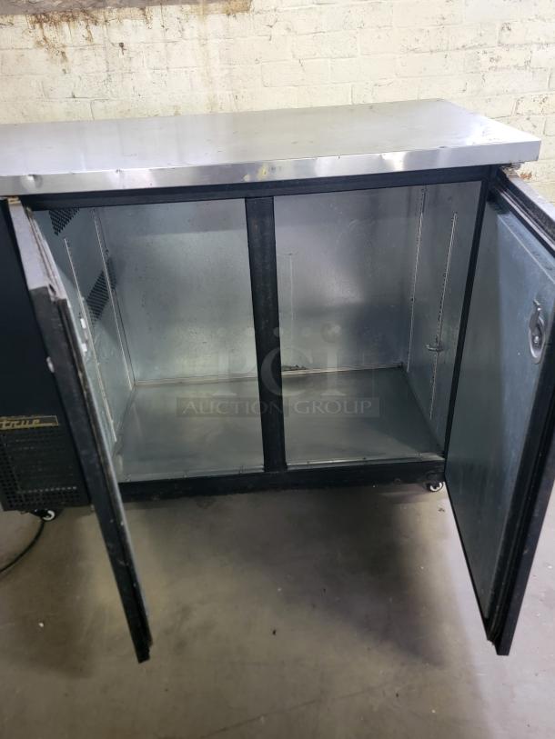 True TBB-50 Back Bar Refrigerator, open doors, stainless steel top, spacious interior, ideal for bars and restaurants.