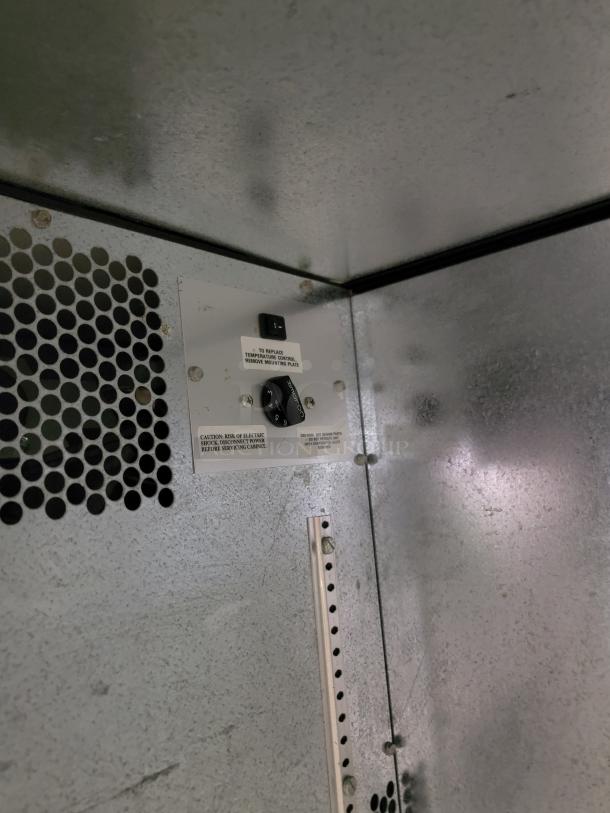 True TBB-50 Back Bar Refrigerator interior, showing temperature control and caution labels, ideal for bars.