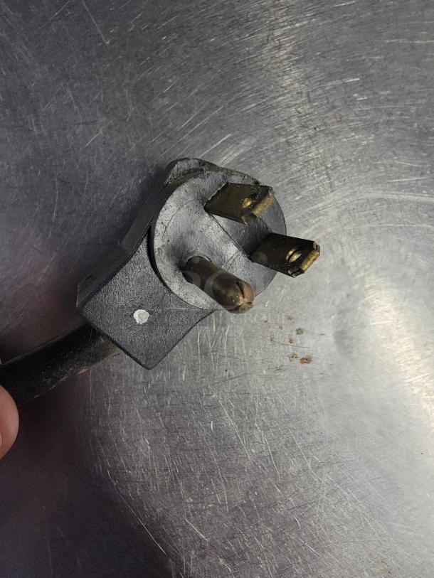 Close-up image of a worn three-prong plug on a Beverage-Air SF34HC-B bottle cooler, indicating use and functional condition.