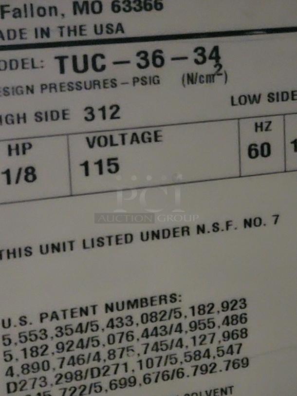 A close-up image of a label showing model TUC-36-34, design pressures, voltage, and U.S. patent numbers.