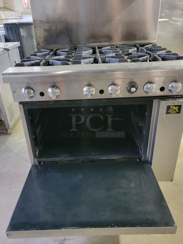 Imperial IR-6 commercial 6-burner gas range, heavy-duty, with oven, suitable for restaurants or catering businesses. Visible wear.