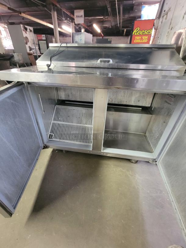 Continental SW48-LC commercial prep table refrigerator with open doors, wire shelving, and stainless finish, ideal for deli use.