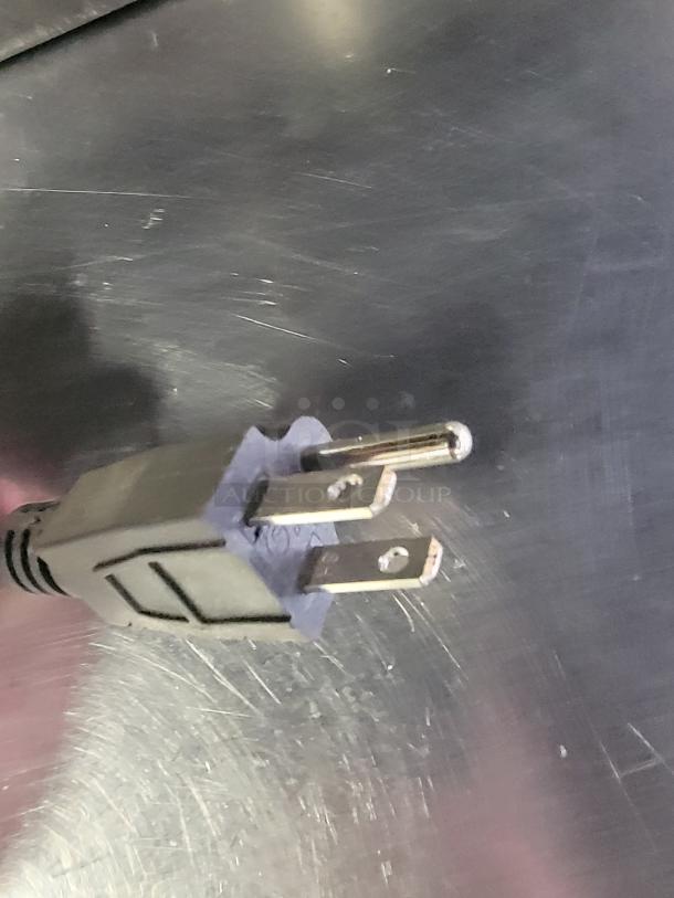 Power plug of a Continental Commercial Prep Table, Model SW48-LC, shown against a stainless steel surface.