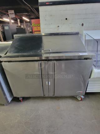 Fagor FST-48-12 refrigerated prep table in stainless steel. Features dual doors, top lid, and caster wheels. Ideal for food prep.