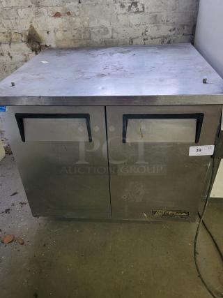 True TUC-36-34 undercounter commercial refrigerator with dual doors, stainless steel, visible wear, ideal for food storage.