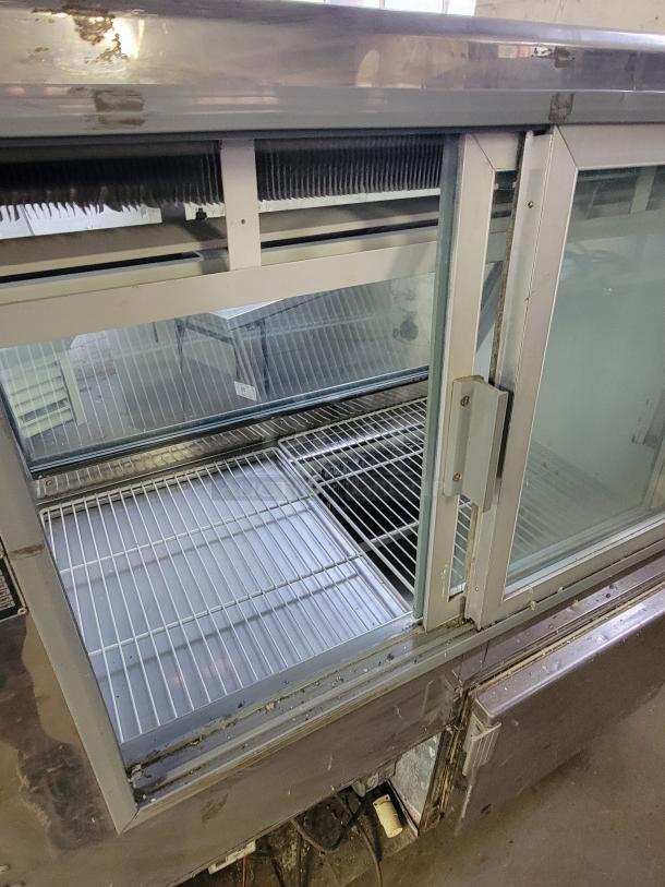 Pinnacle SC734 refrigerated display case with sliding glass doors, metal shelves, and stainless steel frame. Suitable for cafe or bakery.