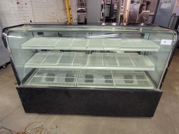 69" refrigerated display case with cracked side glass panels. Features interior shelving for chilled items. Make and model unknown.