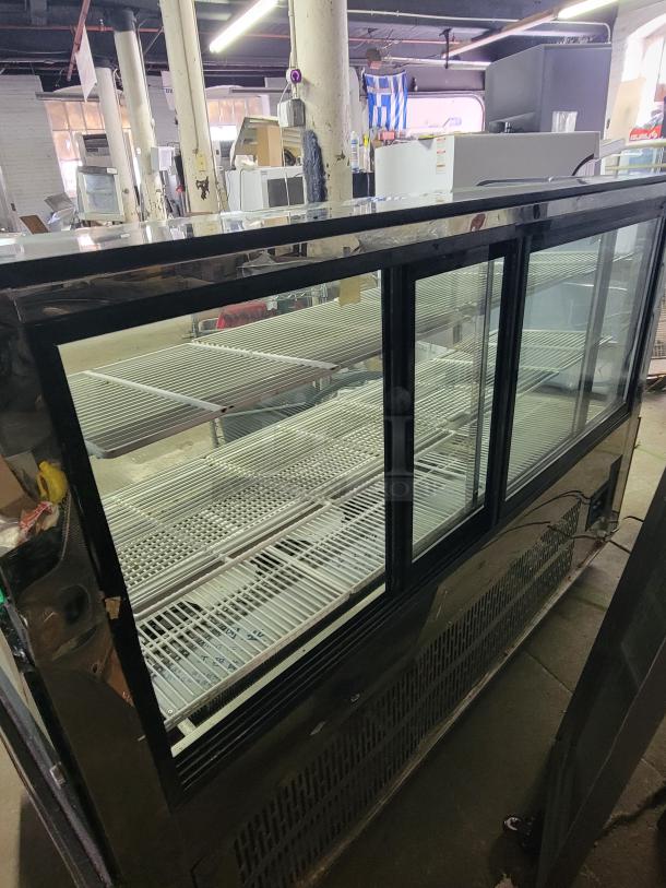 69" refrigerated display case with cracked side glass panels, spacious shelves for chilled items, unknown make and model.