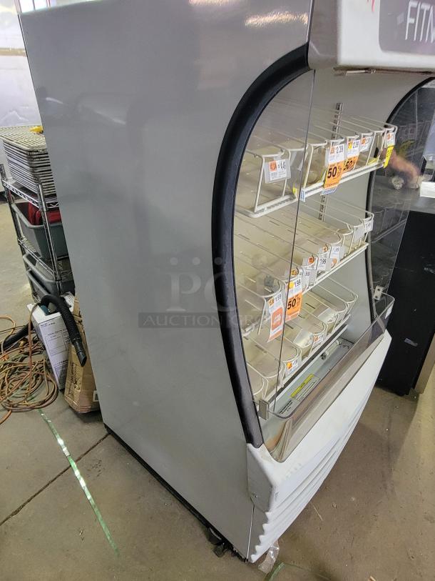 Beverage-Air BZ13-1-W vertical display refrigerator, open-front, commercial use, showcases snacks, visible price tags.