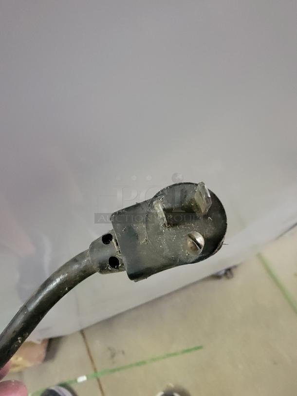 Close-up of a power plug for Beverage-Air vertical display refrigerator model BZ13-1-W, showing three-prong connection.