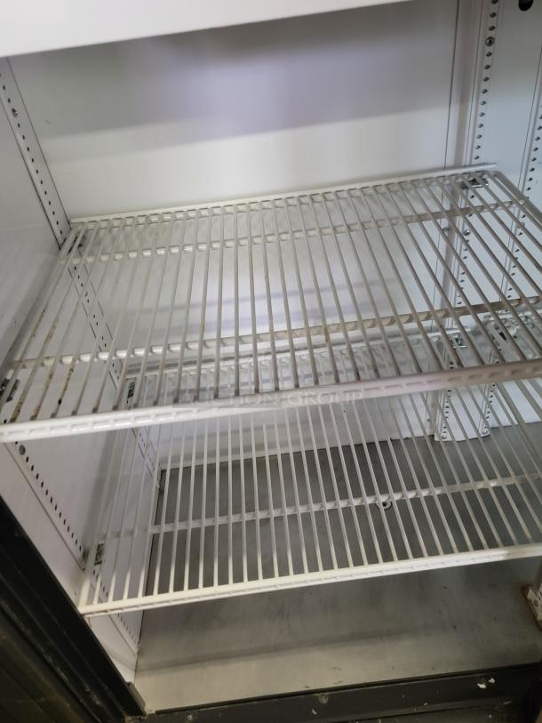 True GDM41SL48HC commercial refrigerator, two-door, interior metal shelving, gently used condition, ideal for businesses.
