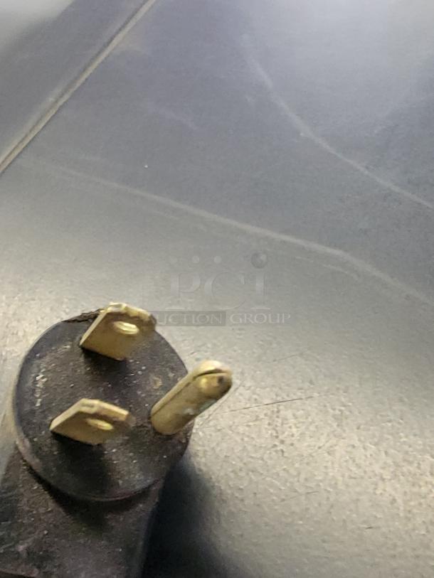 Close-up of a power plug for a Beverage-Air BZ13-1-W open-air merchandiser. Three-prong plug showing wear.