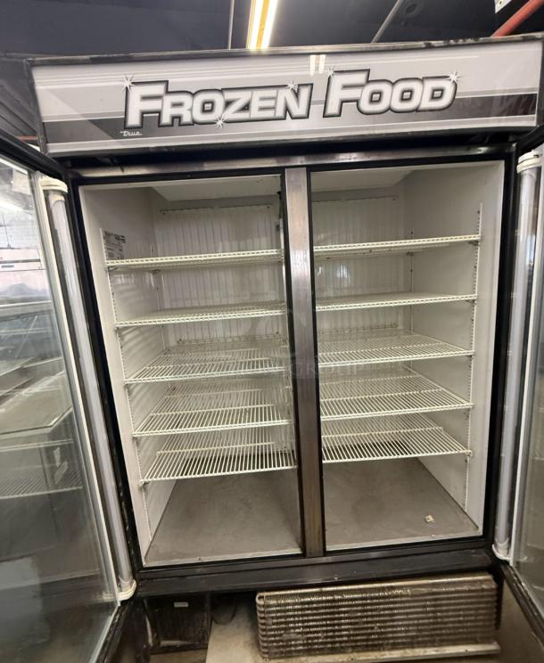 True GDM-49F two-door glass reach-in freezer, commercial-grade with ample shelving, labeled "Frozen Food," in used condition.