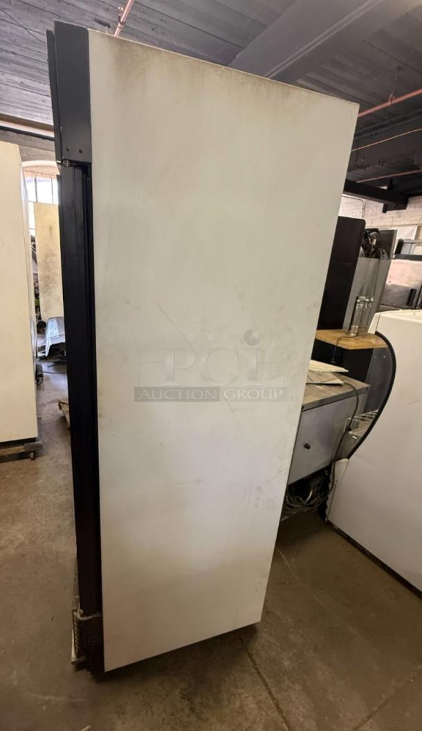 True GDM-49F reach-in freezer, commercial-grade, two glass doors, visible wear, ideal for businesses needing reliable storage.