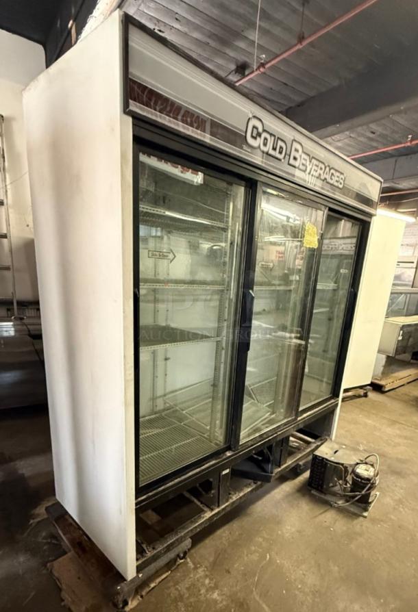 True GDM-69 commercial refrigerator with three glass sliding doors, large capacity, visible "Cold Beverages" sign, in used condition.