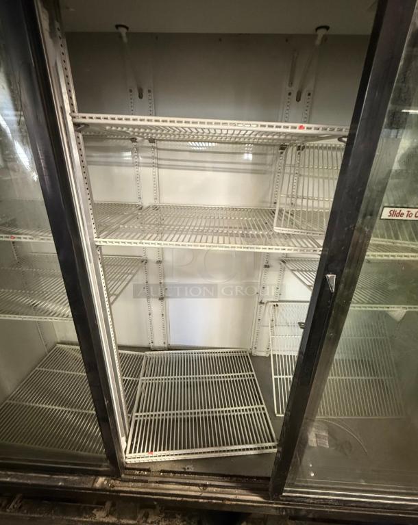 True GDM-69 three-glass door commercial refrigerator, excellent for retail. Features adjustable shelves, sliding doors.