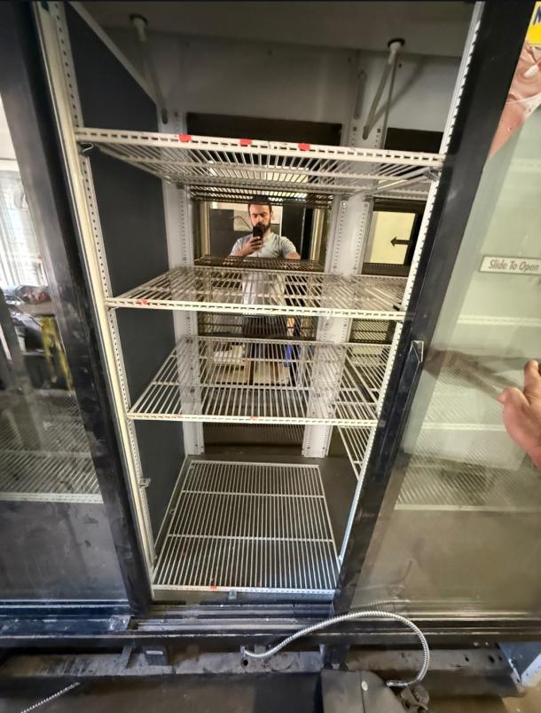 True GDM-69 commercial refrigerator, three sliding glass doors, interior shelving, suitable for retail display.