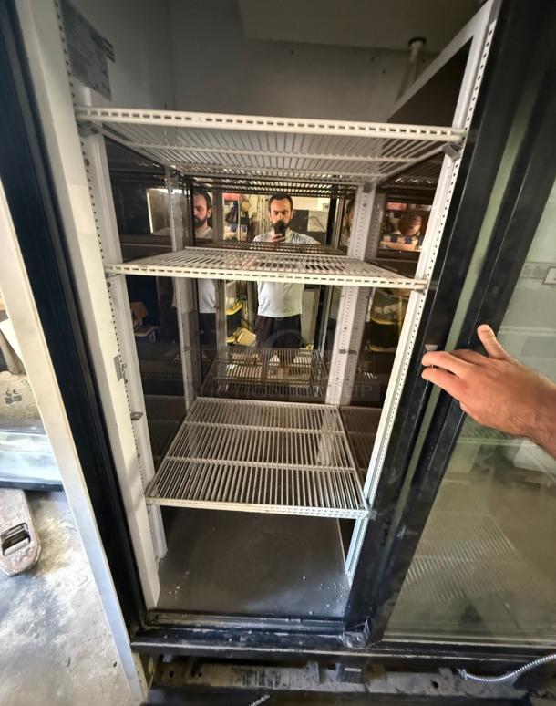 True GDM-69 commercial refrigerator with three glass sliding doors, spacious interior, white shelving, suitable for retail display.