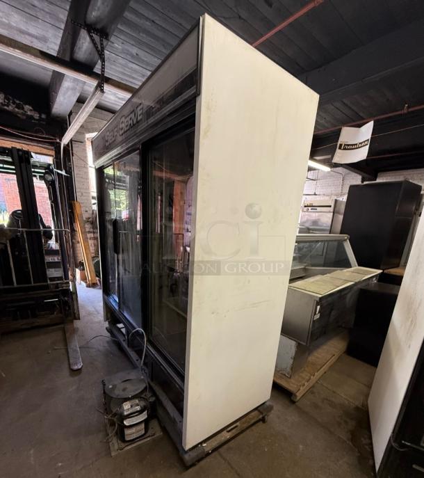 TRUE GDM-69 commercial refrigerator with three sliding glass doors, large capacity, suitable for retail display, visible self-serve label.