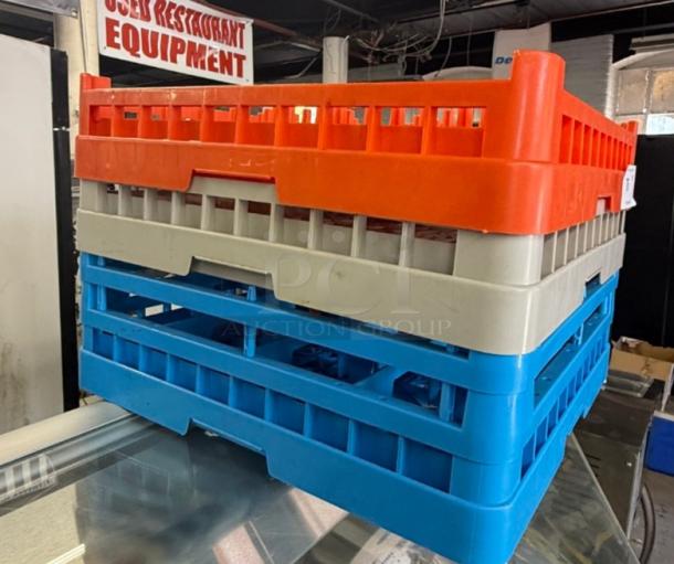 Stack of three commercial dishwasher racks, 19x19 inches, in vibrant orange, beige, and blue. Ideal for restaurant use.