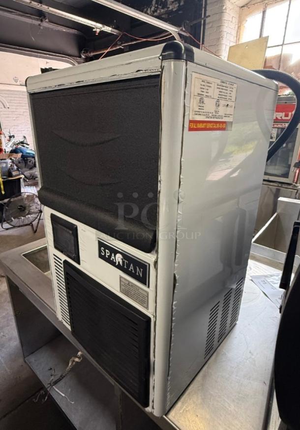Compact Spartan SUIM-68 ice maker in good condition. Features visible brand logo, control panel, and warranty label. Perfect for cafes.
