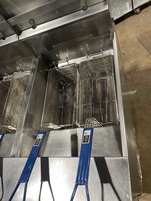 Pitco FGSGH50 4-bay stainless steel fryer, natural gas, with baskets, oil filter, and blue gas hose. On casters.