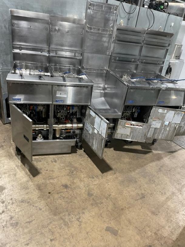Pitco FG-SGH50 stainless steel 4-bay fryer system with basket hanger, oil filter, and gas connection hose on casters.