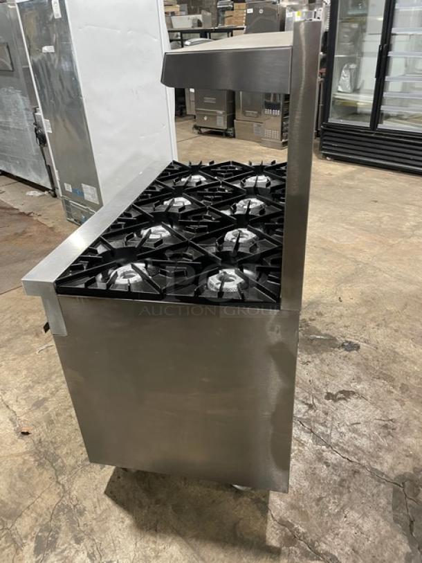 Vulcan stainless steel 8 burner range/oven with backsplash, overhead salamander shelf, and enclosed storage on casters.