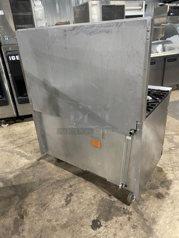 Vulcan commercial stainless steel 8 burner range/oven combo with backsplash, overhead salamander shelf, cabinet storage, and casters.
