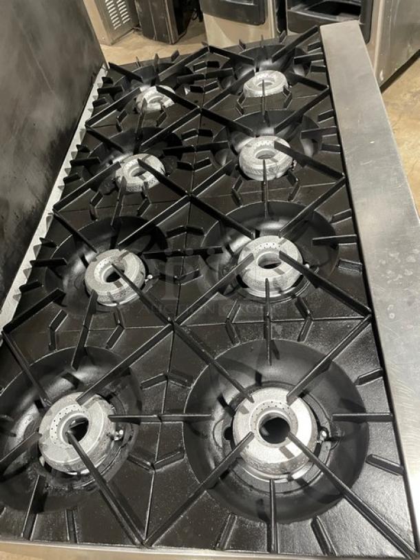 Vulcan commercial stainless steel 8 burner range/oven combo, natural gas, with backsplash, salamander shelf, and storage.