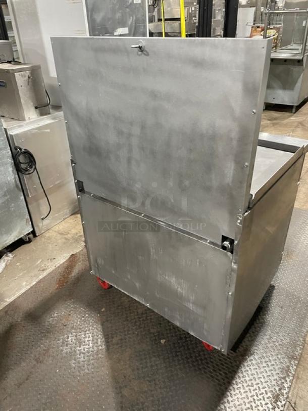 Migali commercial stainless steel griddle range/oven combo with backsplash, wired oven racks, and casters. Visible back view.
