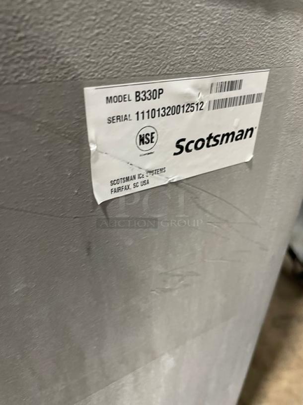 Scotsman Prodigy ice machine label showing model B330P, serial 11101320012512, NSF certified, stainless steel surface.