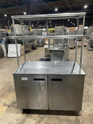 Delfield UC4048-STAR stainless steel 2-door refrigerated worktop table with double overhead shelf, Energy Star certified, on casters.