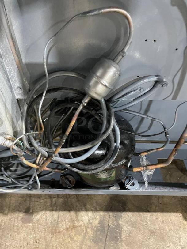 Delfield UC4048STAR compressor wiring detail; shows industrial connection setup on stainless steel refrigerated table.