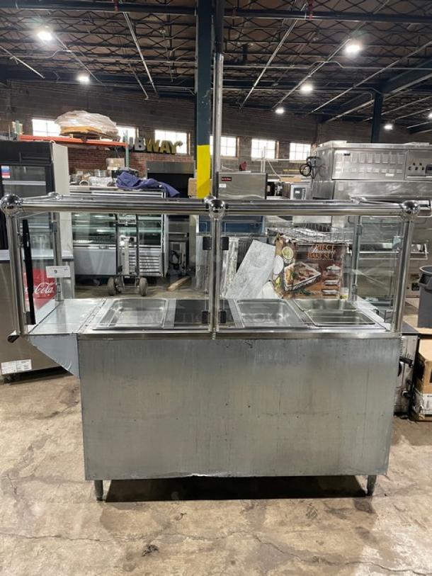 Custom stainless steel 4-well steamtable with sneeze guard, natural gas powered, includes hotel pans, on sturdy legs.