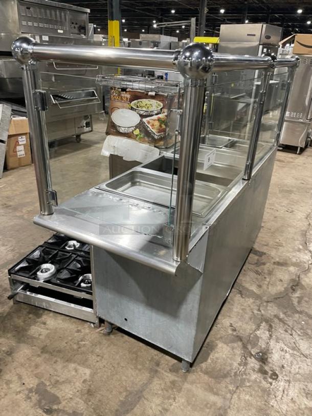 Custom commercial stainless steel 4-well steamtable with sneeze guard, hotel pans, and natural gas power on legs.