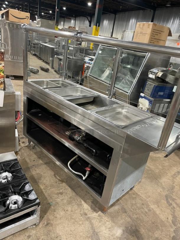 Custom commercial stainless steel 4-well hot food steamtable with sneeze guard, hotel pans, and sturdy legs.